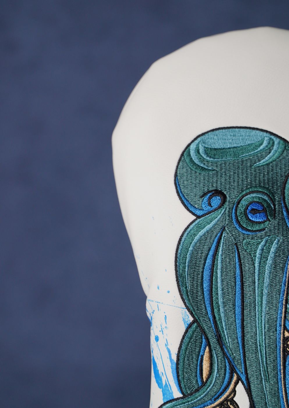Close-up of a detailed octopus design on a golf headcover with a dark blue background.