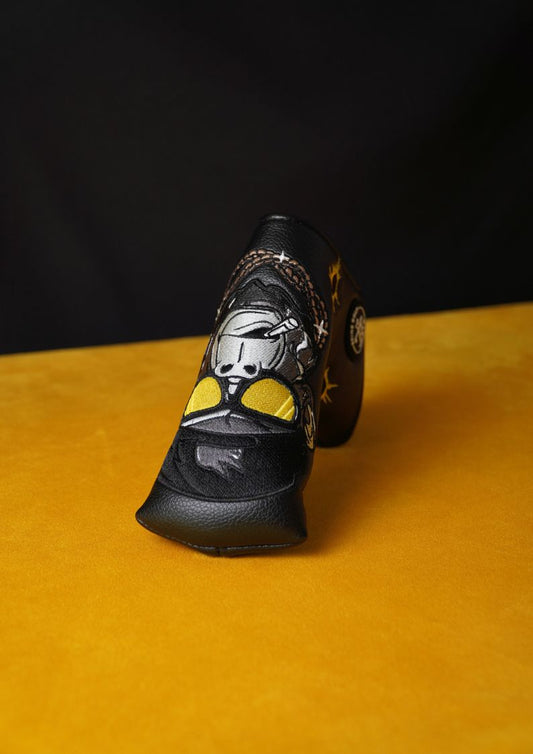 Black golf headcover with gorilla design on a yellow surface