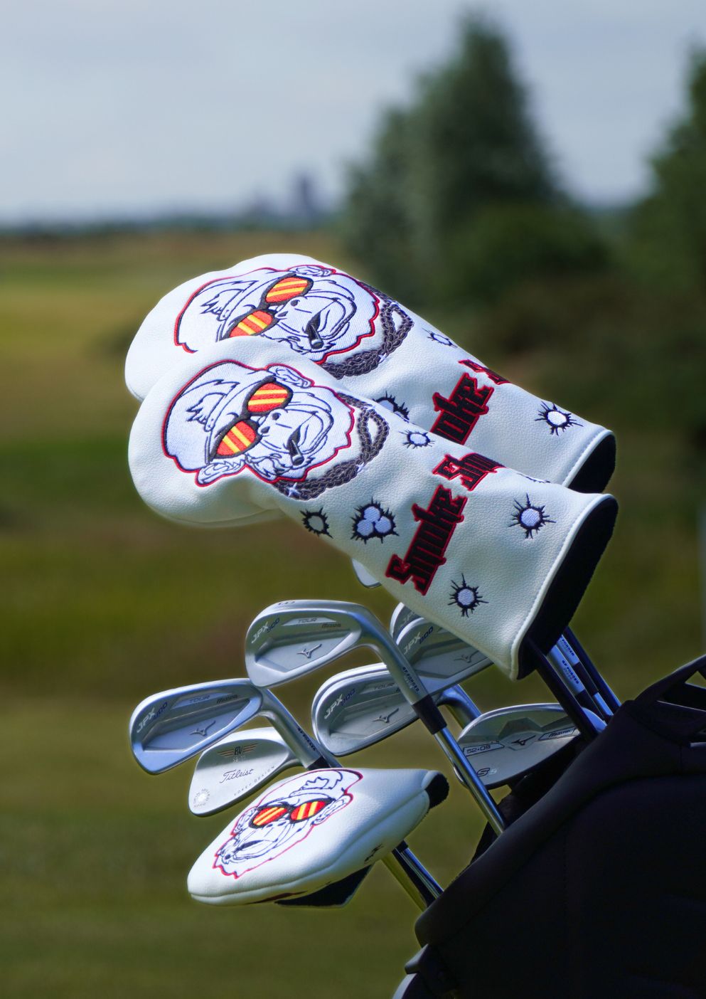 Golf club head cover with gorilla design on a blurred golf course background