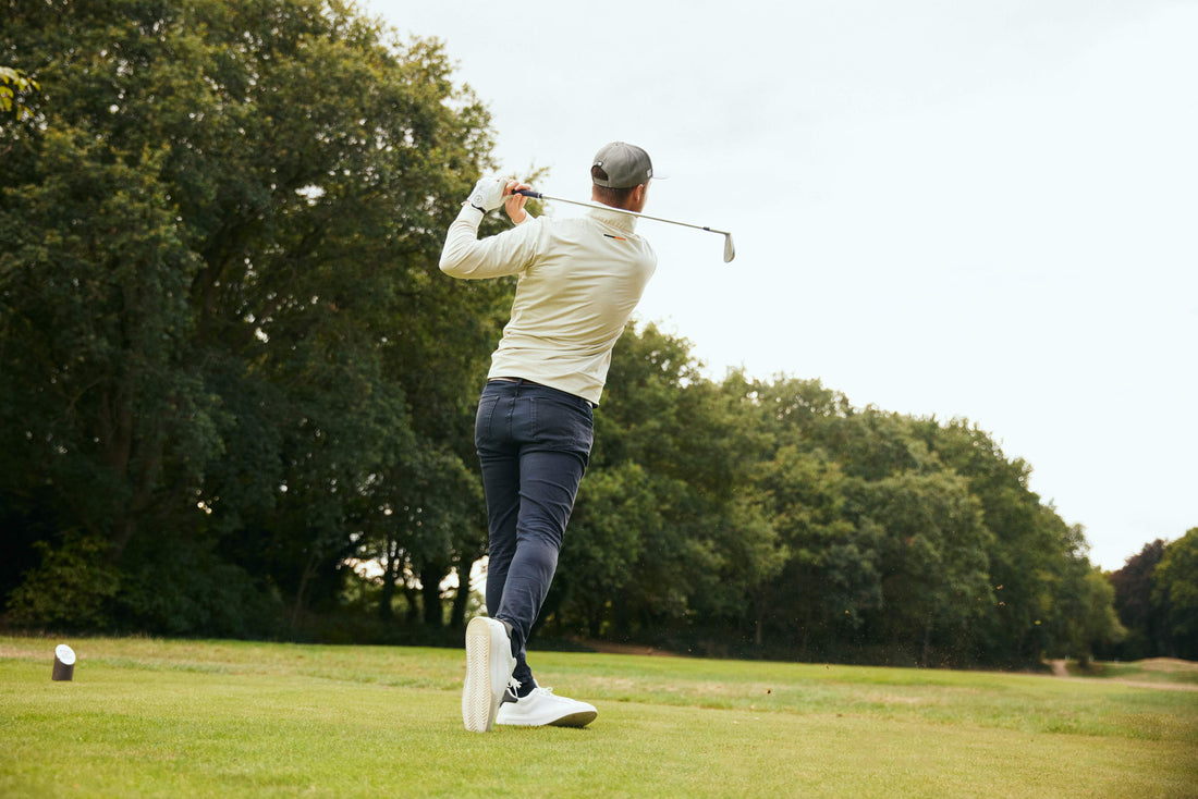 Golfer wearing quarter zip hitting golf shot