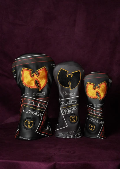Three custom golf club headcovers featuring a black background with a large gold and orange Wu-Tang Clan logo and white text, displayed on a dark purple fabric background.