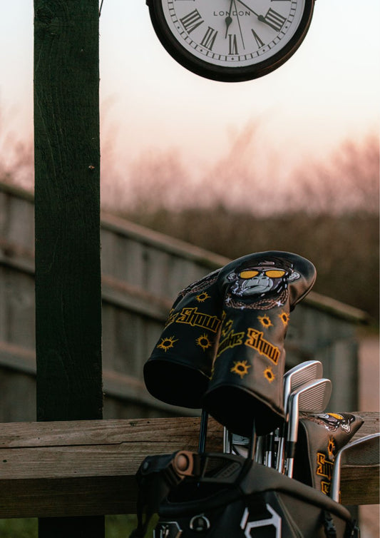 Golf clubs with a bag and clock on a wooden surface