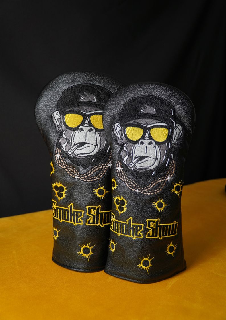 Two golf club head covers with monkey design and 'Smoke Show' text on a black background.