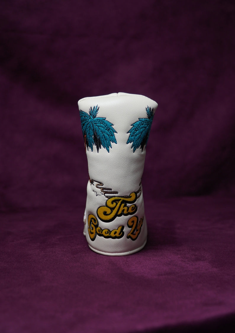 White golf head cover with blue palm tree designs and 'The Good Life' text on a purple background