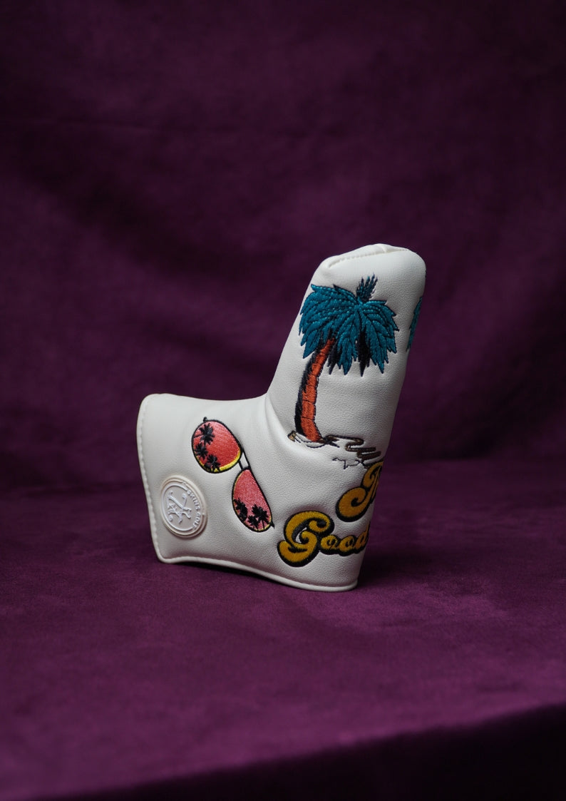 White golf club head cover with palm tree design on a purple background