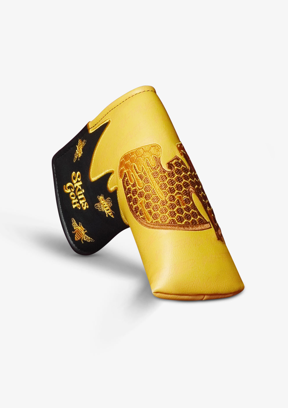 A yellow and black golf club cover featuring a gold honeycomb pattern and bee designs, with the text 'Skins Golf' printed on the black section.