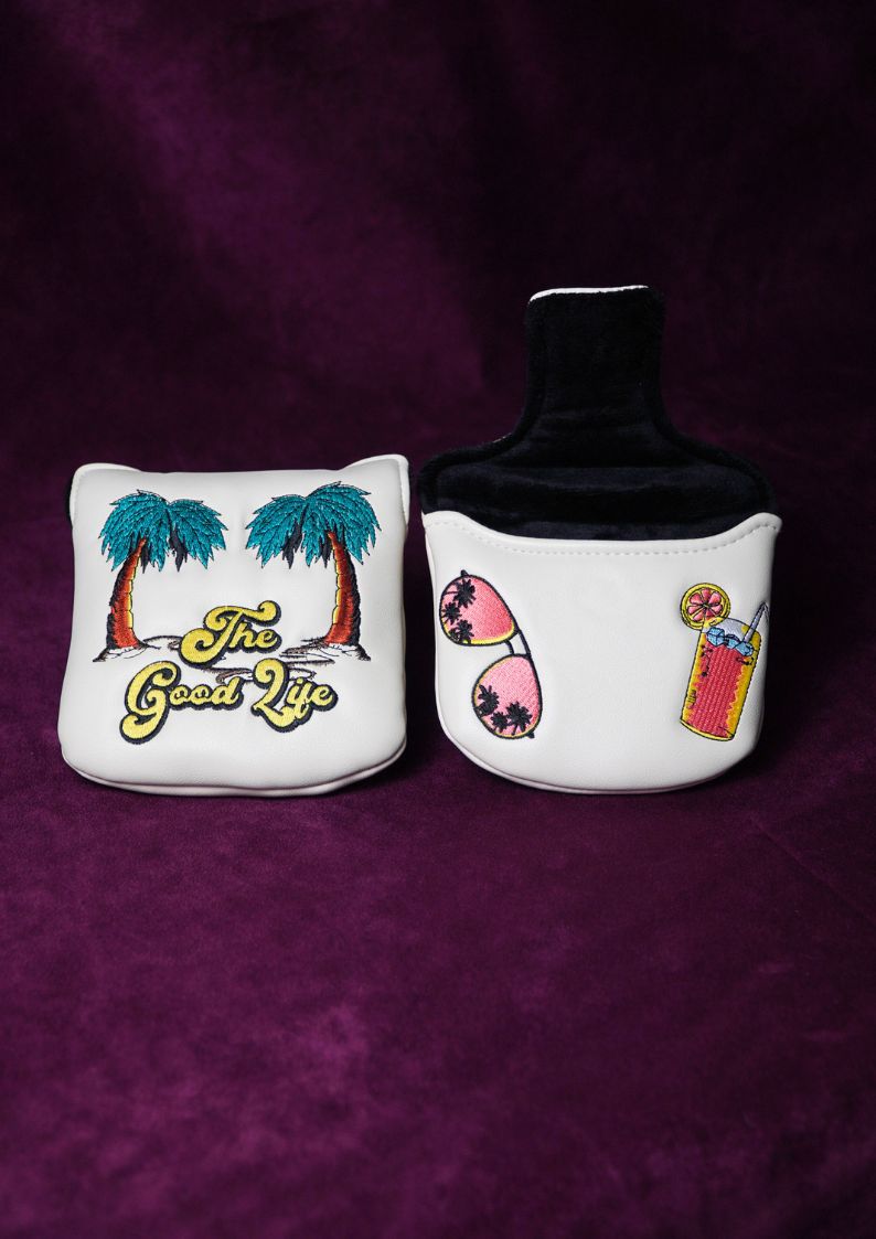 Two decorative mallet headcovers with palm trees and beach-themed designs on a purple background