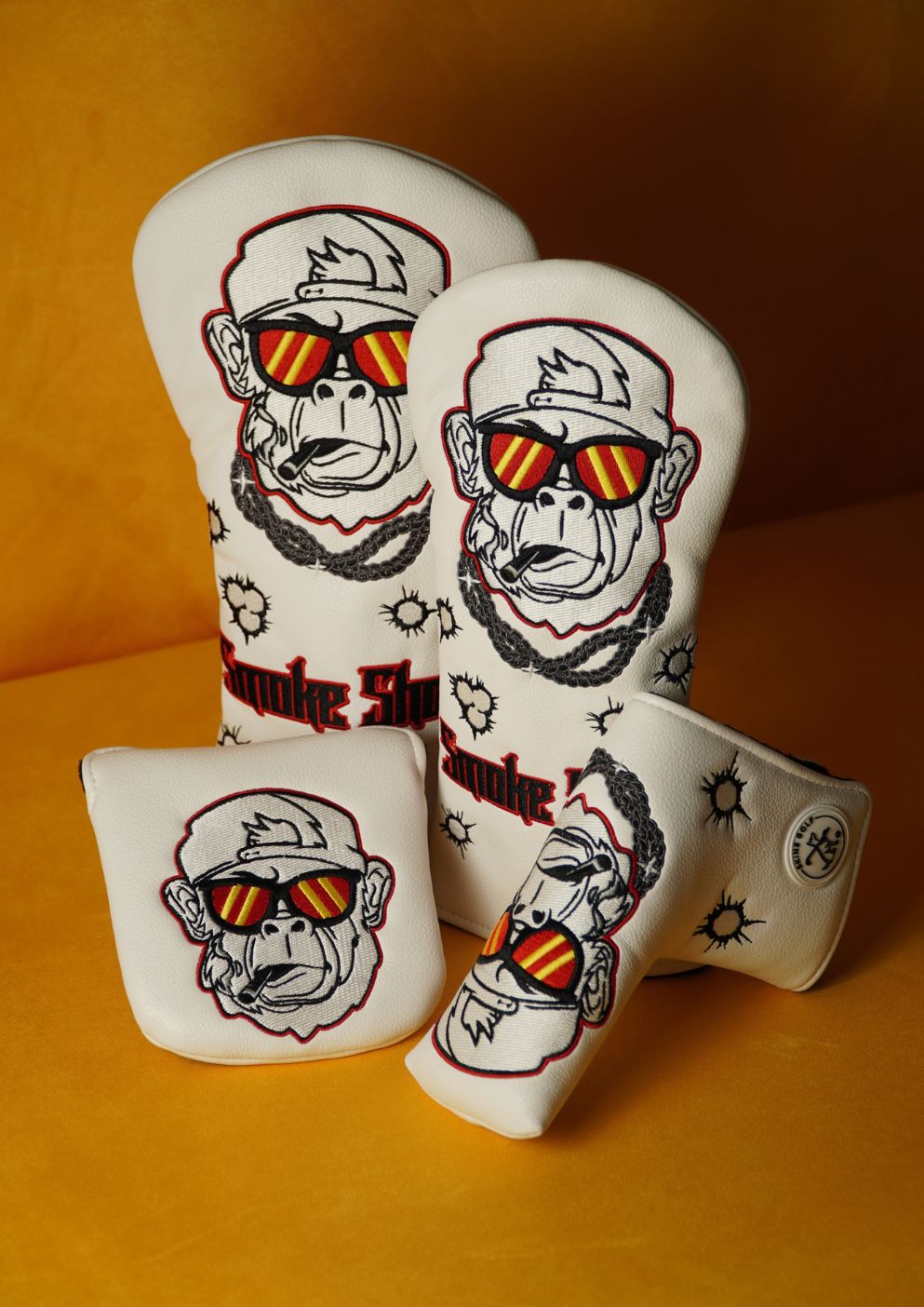 Set of four golf club head covers with monkey design on a yellow background